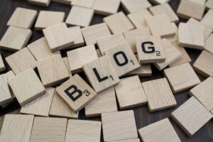 Pisanie artykułów blogowych - grafika do tekstu. Na obrazku: słowo BLOG ułożone z drewnianych kostek. Autor zdjęcia: Nadiia Ganzhyi, źródło: Unsplash.