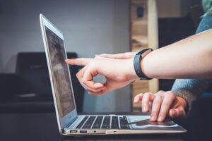 Jak stworzyć stronę przyjazną klientom? - grafika do tekstu. Na obrazku: osoby sprawdzające coś na laptopie. Autor: JohnFlPc9, źródło: Unsplash.