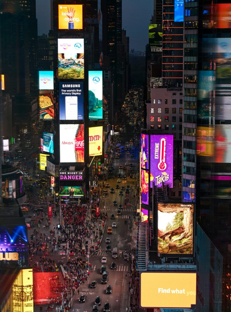 Błędy w tekstach sprzedażowych - grafika do tekstu. Na obrazku: Świecące billboardy. Autor: Val Vesa, źródło: Unsplash.